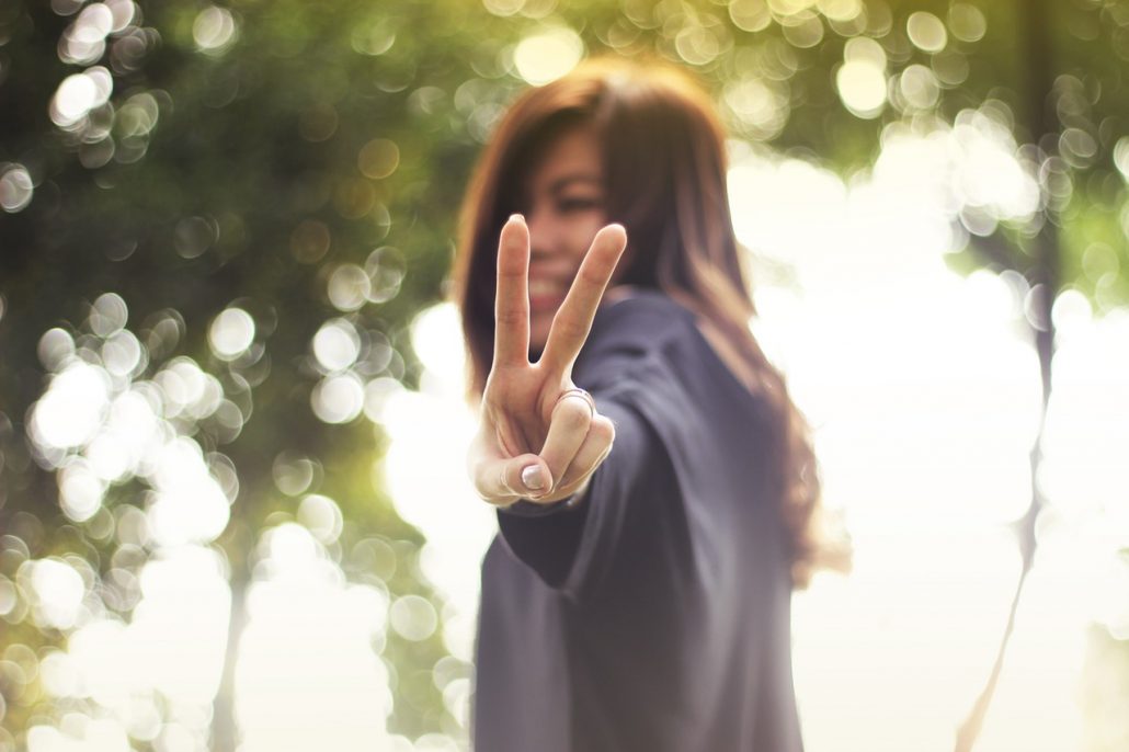 Happy woman giving peace sign