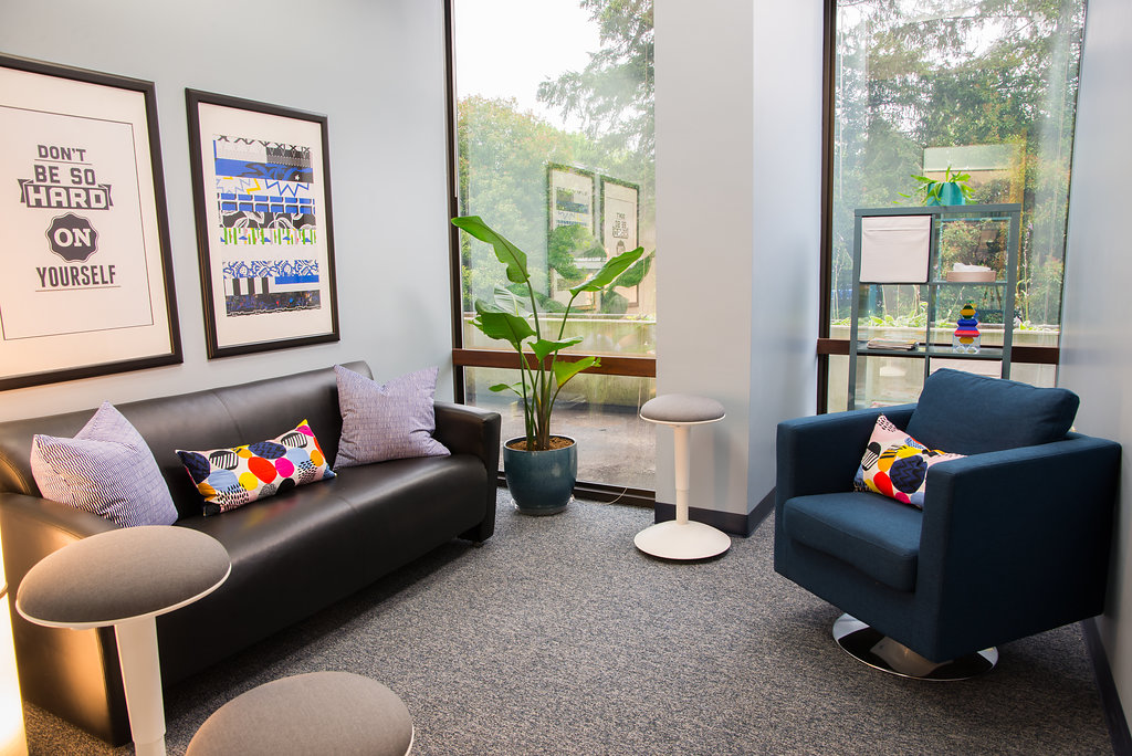 room with leather couch and a blue chair at center of excellence